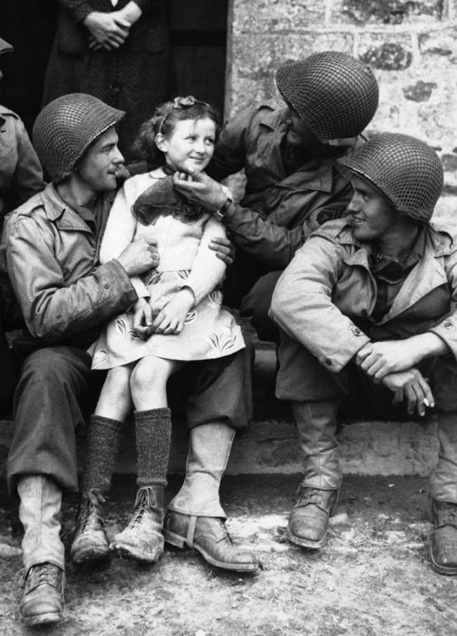#32 A little French girl finds three admirers from the ranks of American forces who have made a speedy and successful advance through Normandy, France, 1944.