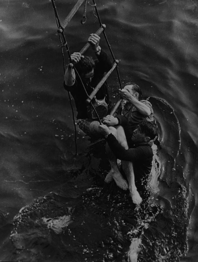 #1 Operation Dynamo: Three men being rescued from the sea after having to abandon ship during their evacuation from the beaches at Dunkirk, 1940.