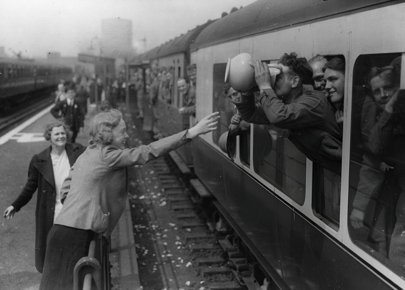 #28 A long drink for a member of the BEF at the end of his journey home from Dunkirk, 1940.