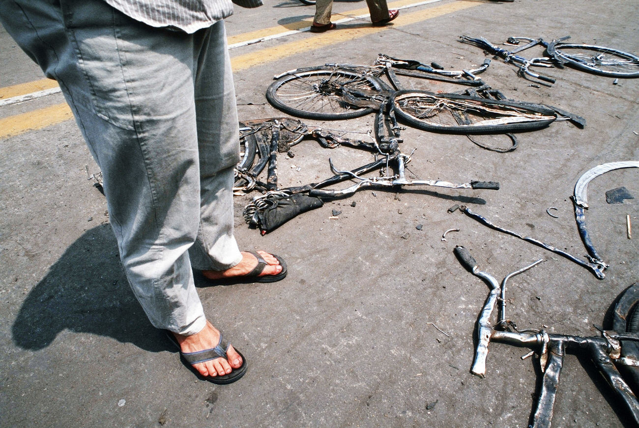 #24 Locals stop to look at bicycles flattened by the Chinese army tanks.