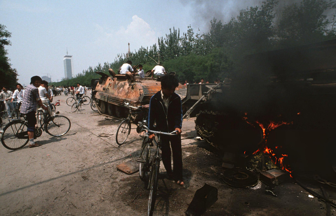 #57 Onlookers examine Chinese Army trucks and vehicles that were damaged or destroyed, 1989.