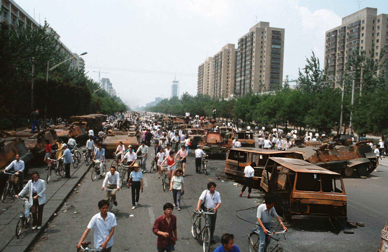 #58 Onlookers examine Chinese Army trucks and vehicles that were damaged or destroyed, 1989.