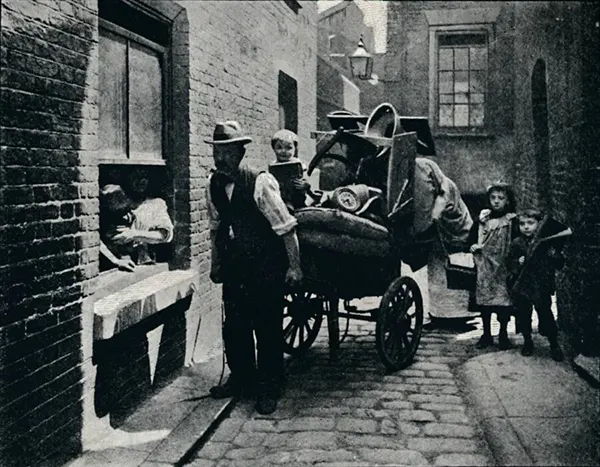 #2 In the slums, families had to carry all their belongings when forced to move due to eviction. This photograph from around 1901 captures a family during such a relocation.