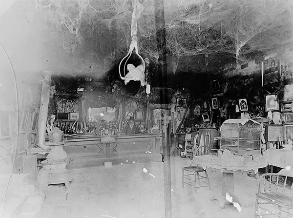#16 The interior of Cobweb Palace, known for its eccentric owner Abe Warner, who allowed spiders to spin countless webs throughout the establishment.