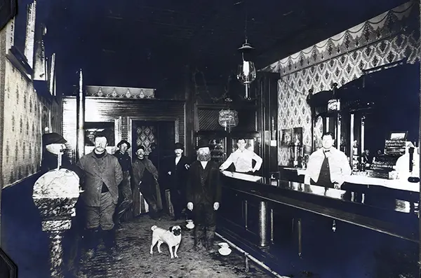 #3 Several men, and a dog named Peggie, stand in John Powell’s Saloon in Plainfield, Illinois, 1910s.