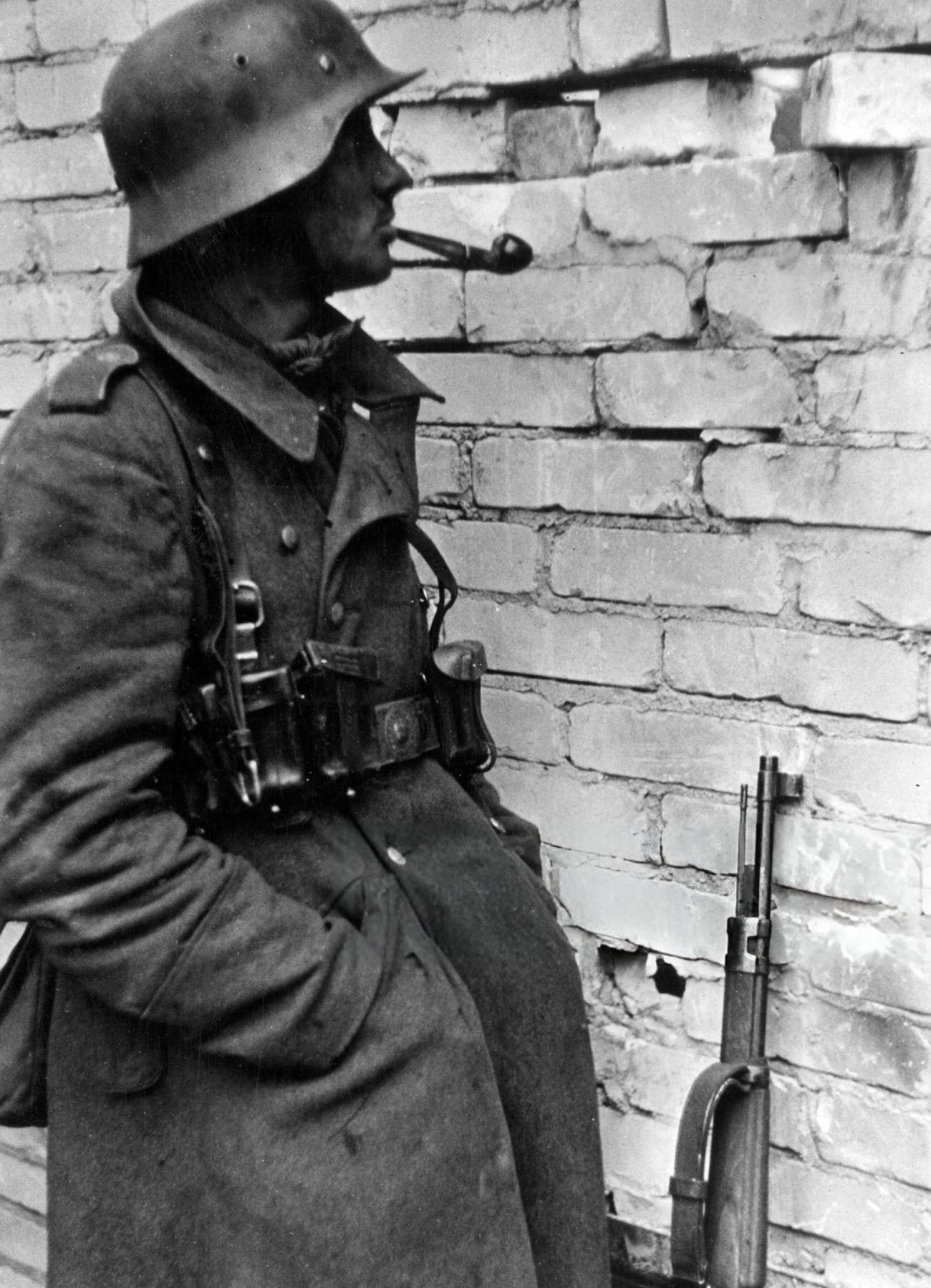 #58 German sentry observing Russian soldiers moves through a wall’s hole in Stalingrad, 1942.