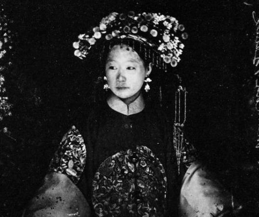 #18 In a photograph taken in Peking around 1867, this sumptuously dressed Manchu bride looks as though she’s supporting quite a weight on her head with that headdress.