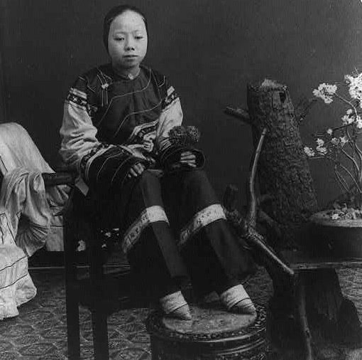 #6 Seated here with her feet up is a ‘lily-footed’ woman – a term for those who had their feet bound as children. In the Chinese culture of the time, the size of a girl’s feet were as important (if not more so) than the appearance of her face.
