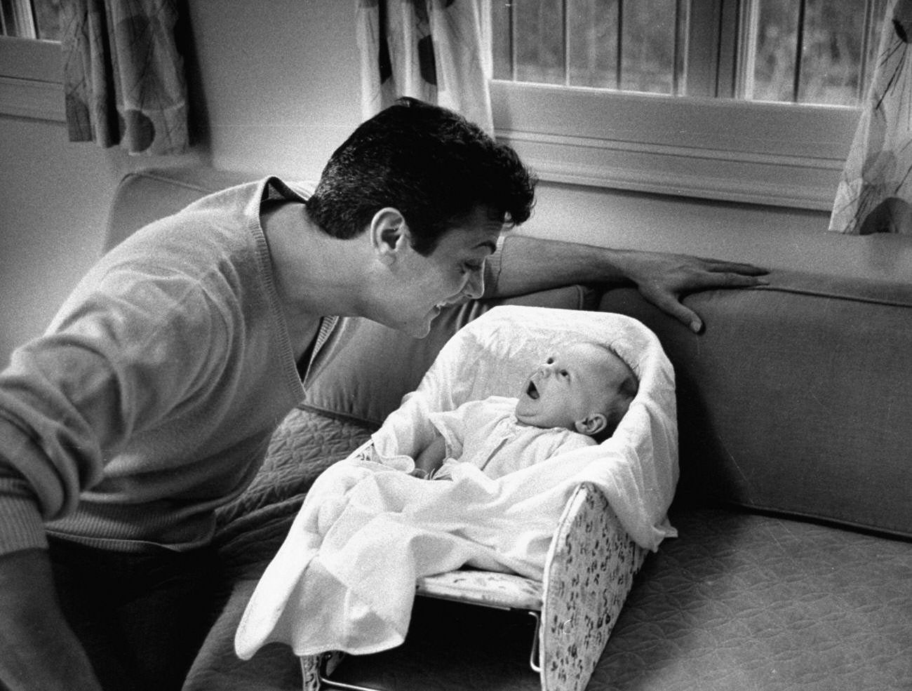 #9 Tony Curtis smiles at his daughter, Jamie Lee, 1959.