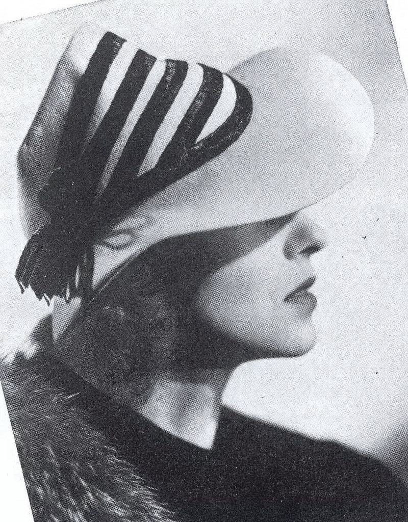 #8 Frances Drake wearing a grey-blue felt hat trimmed with black straw braid, 1937