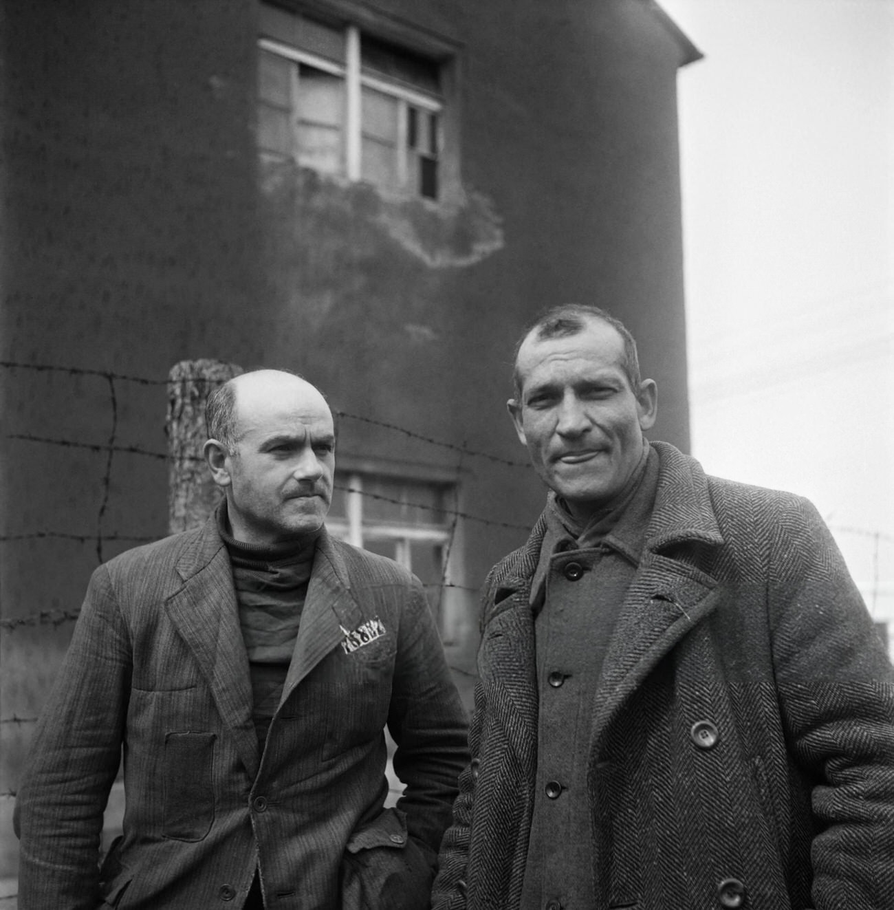 #38 French prisoners Camille Sautereau and commander Bellon talk together in the courtyard of Nazi camp of Buchenwald, 1945.