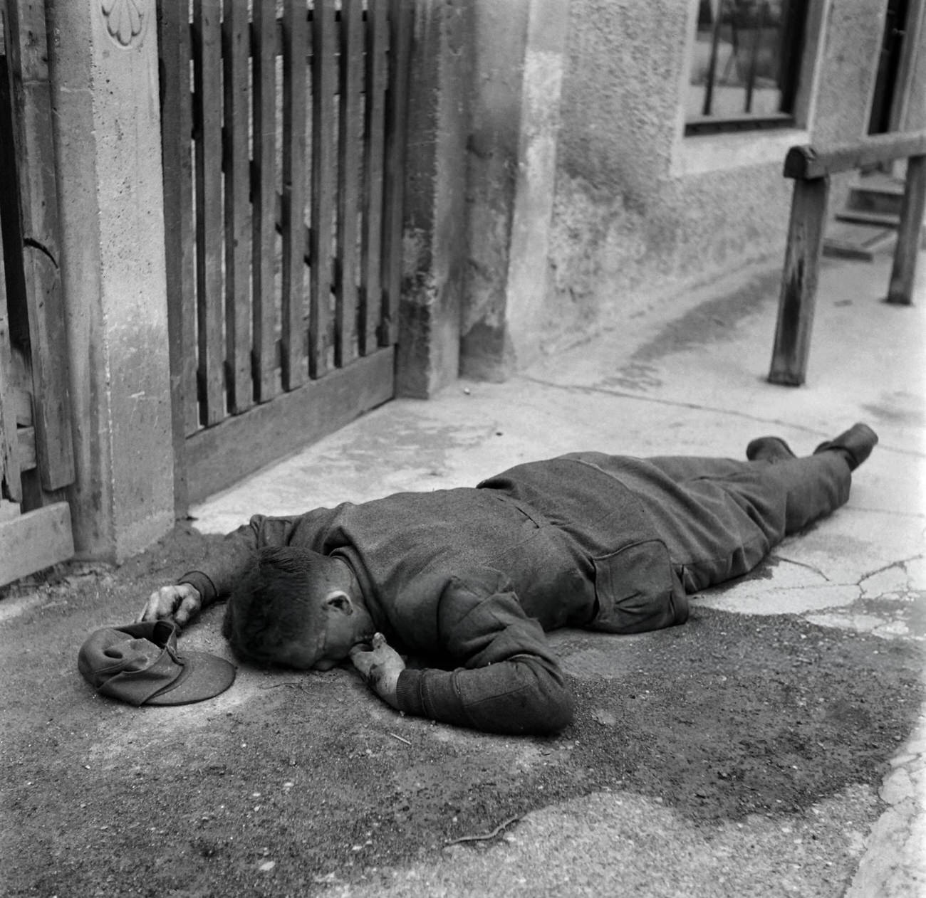 #40 The body of a German soldier lies on the floor of the Dachau concentration camp after the US army liberated the camp, 1945.