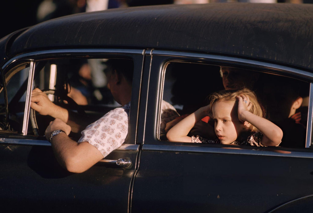 #67 A Little Girl Watches the Mardi Gras Celebrations in New Orleans From the Back Seat of a Car, 1961.