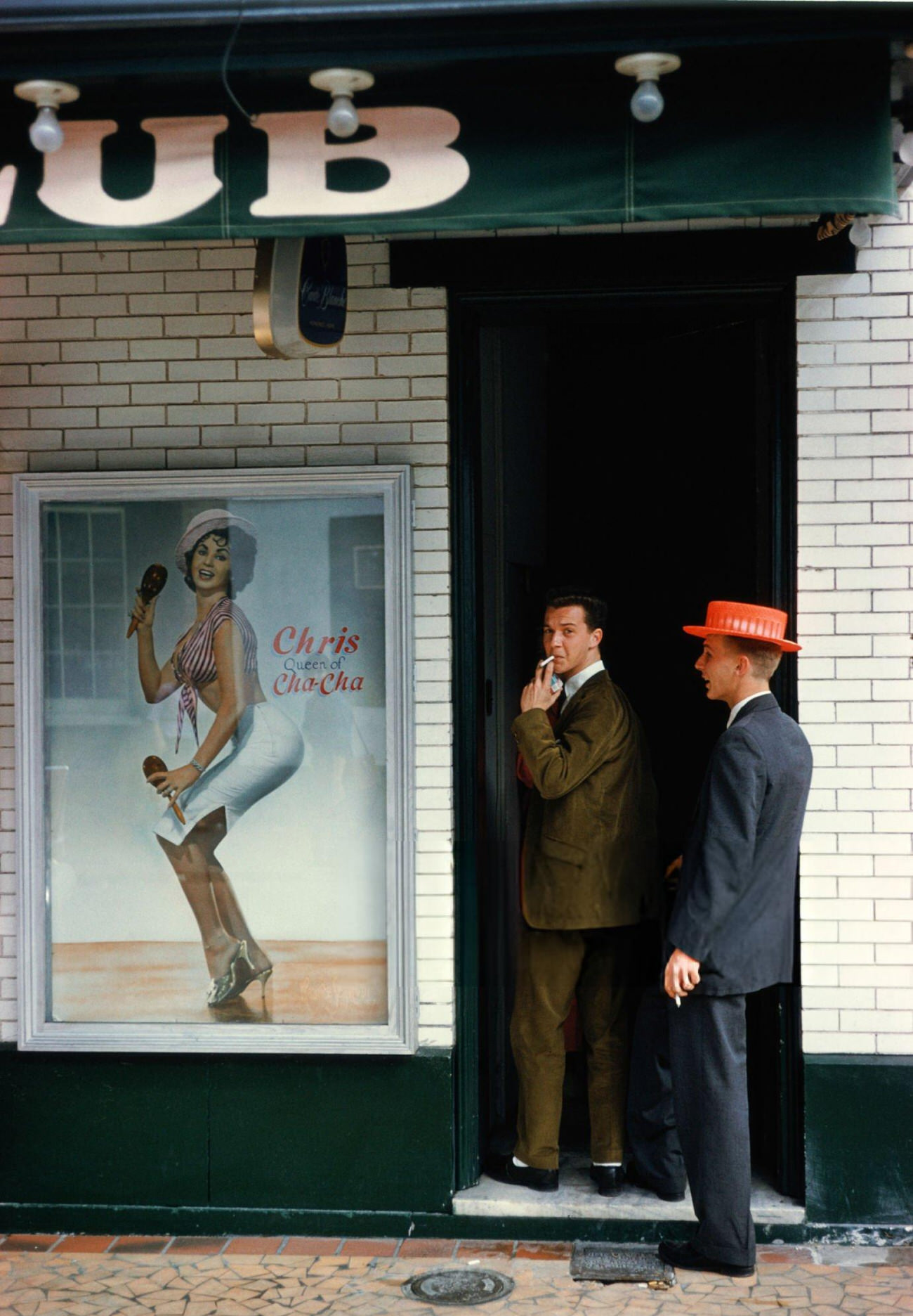 #69 Two Men Enter a Club Which Advertises ‘Chris Queen of the Cha-Cha’ During Mardi Gras in New Orleans, 1961.