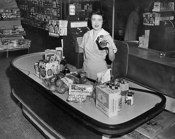 #22 Cashier at the checkout of a grocery store, 1960.