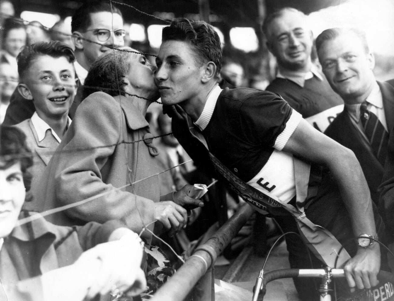 #3 Jacques Anquetil being kissed by his mother after winning the Grand Prix Des Nations, 1953.