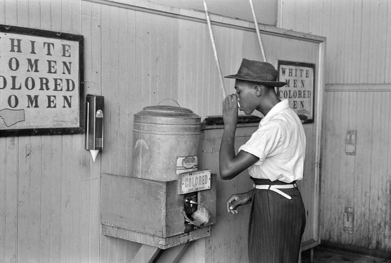 #30 A man drinking at a “Colored” water cooler in Oklahoma City, Oklahoma, 1939.