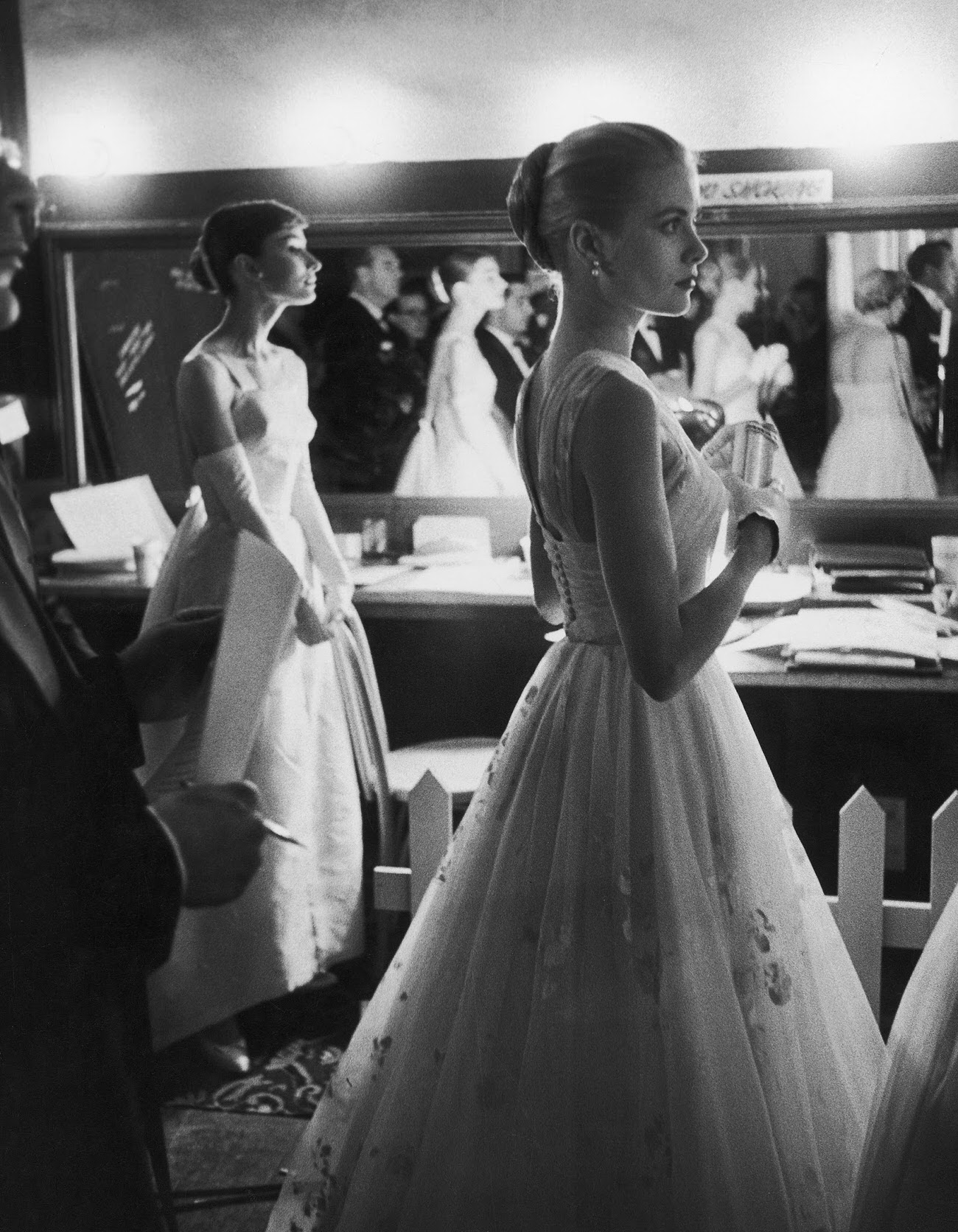 #1 Audrey Hepburn and Grace Kelly wait backstage at the RKO Pantages Theatre during the 28th Annual Academy Awards, 1956.