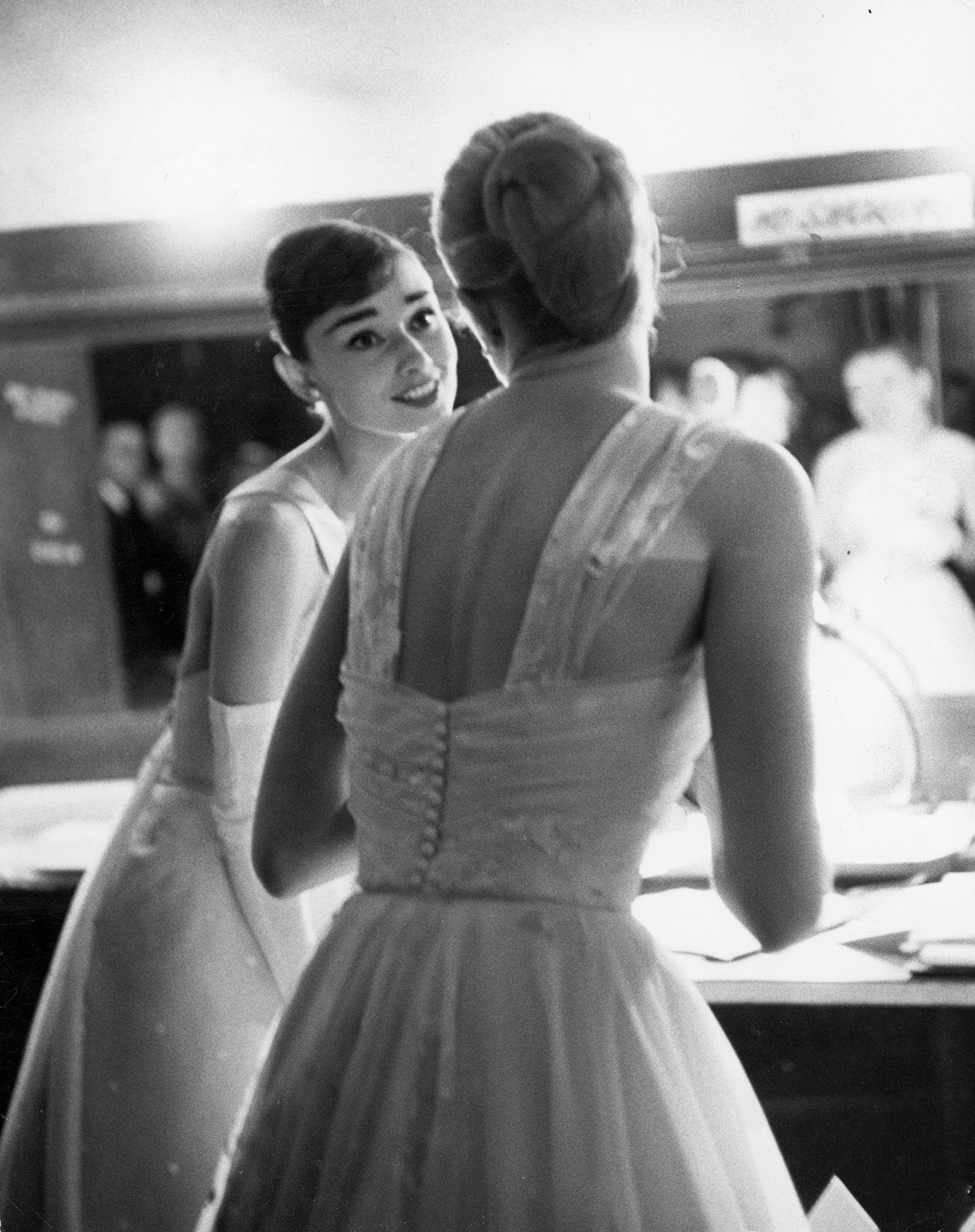 #19 Audrey Hepburn and Grace Kelly backstage at the RKO Pantages Theatre during the 28th Annual Academy Awards, 1956.