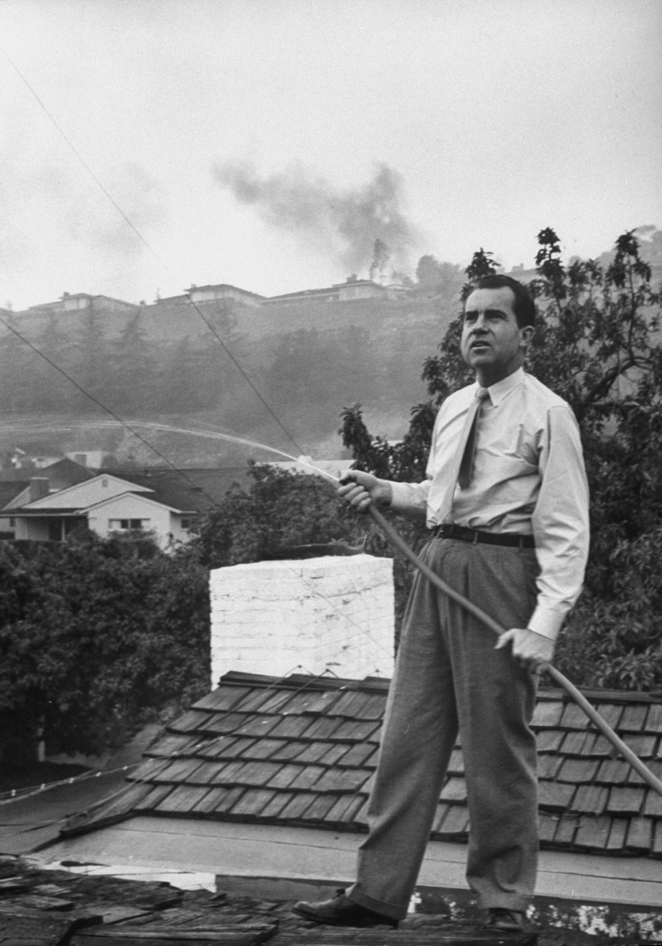 #3 Senator Richard Nixon on the roof of his home in Los Angeles, trying to douse fires caused by a brush blaze, 1961.