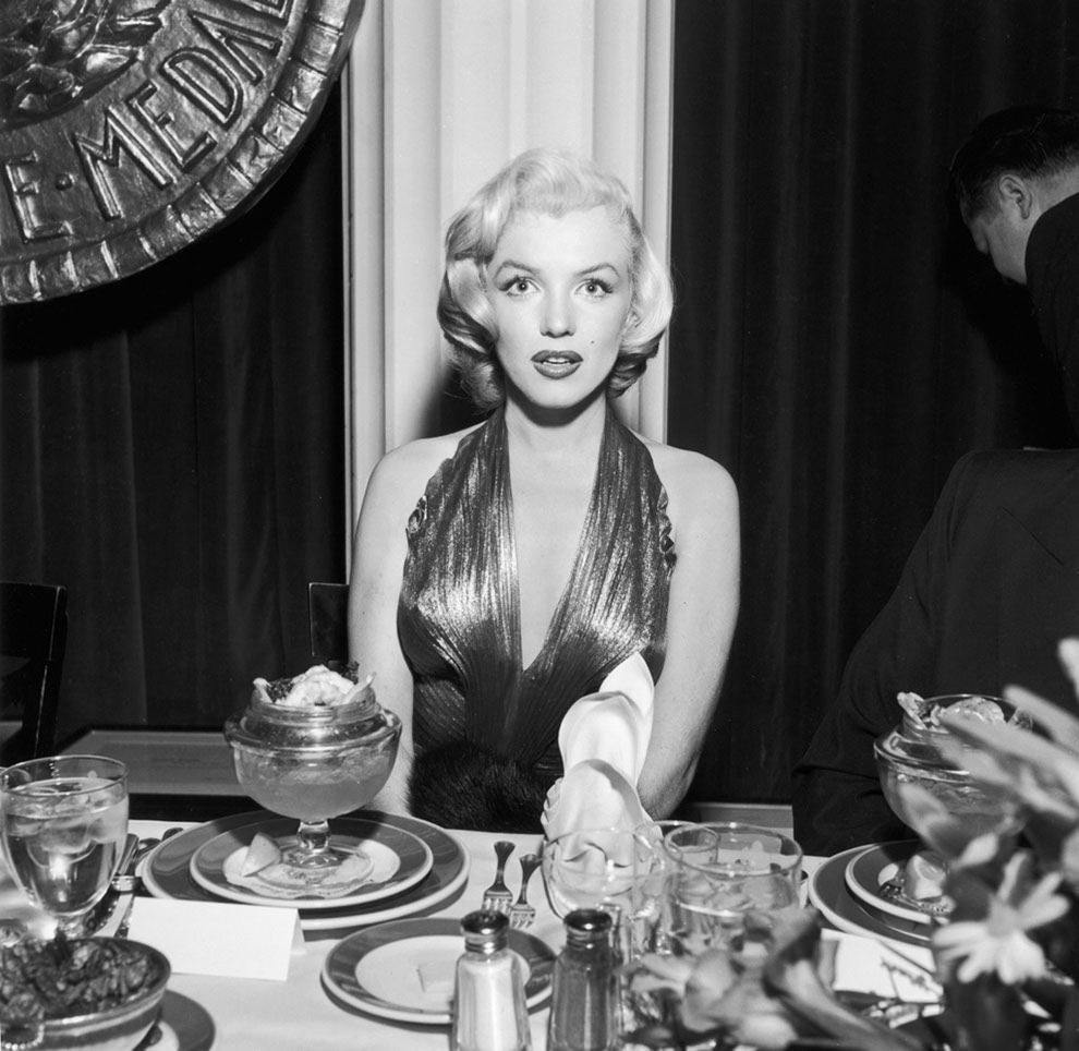 #21 Marilyn Monroe ignoring her dessert. At a banquet table during a Photoplay Gold Medal Awards dinner, 1953.