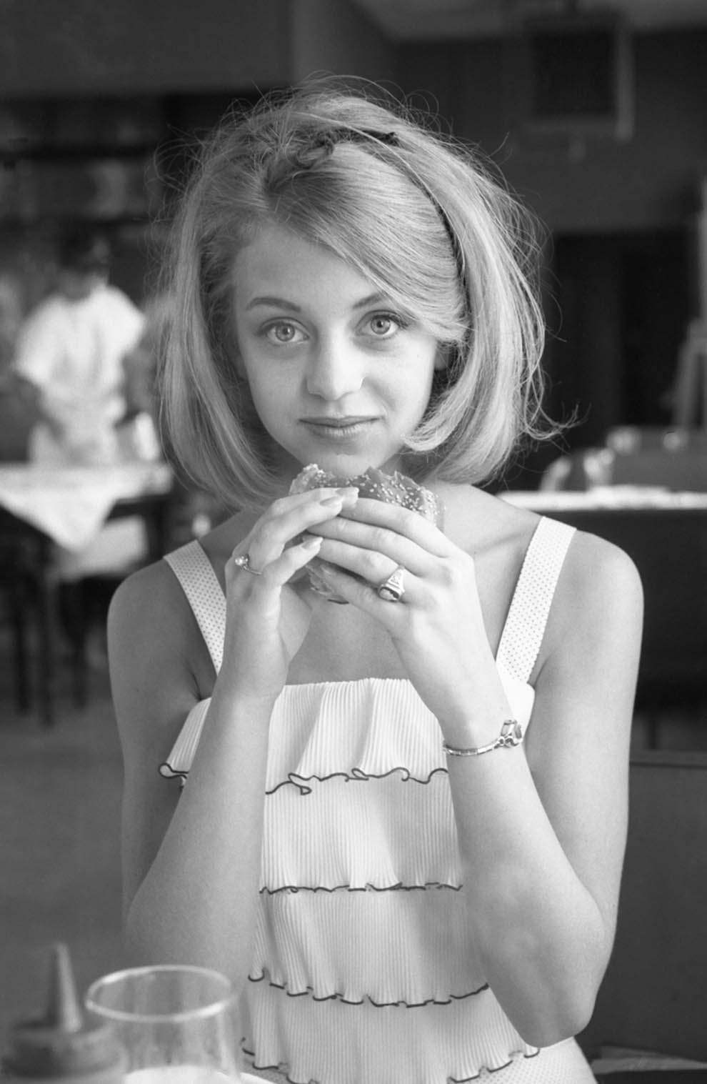 #19 Goldie Hawn contemplating a hamburger. At a restaurant in Washington, DC, 1964