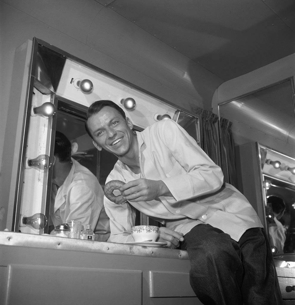 #3 Frank Sinatra putting moves on a doughnut. In his trailer during a break in filming, circa 1950.