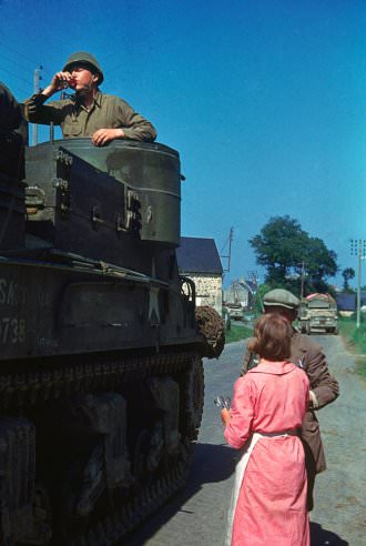 #16 A French couple shares cognac with an American tank crew, northern France, summer 1944