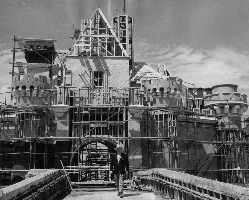 #1 Walt Disney in front of a still-unfinished Sleeping Beauty’s Castle, 1955