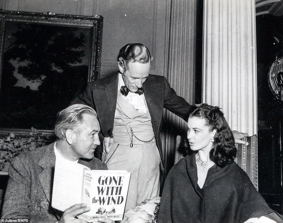 Director Victor Fleming holding the novel ‘Gone With The Wind’ while in discussion with Leslie Howard and Vivien Leigh.