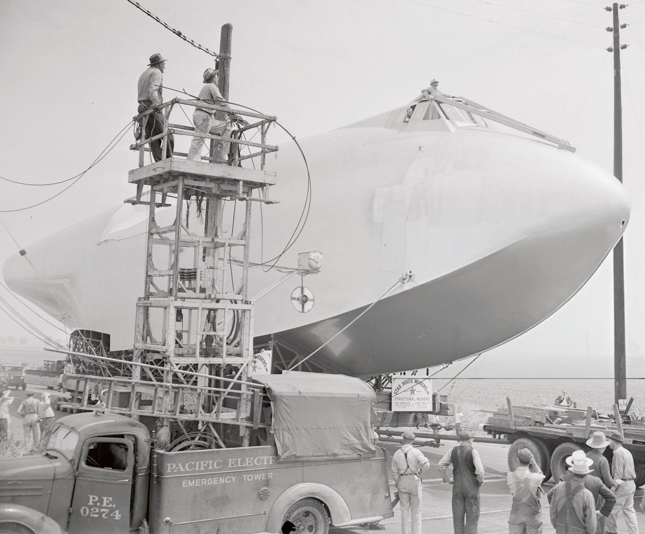 Power lines being removed for the Spruce Goose’s transport, 1940s.