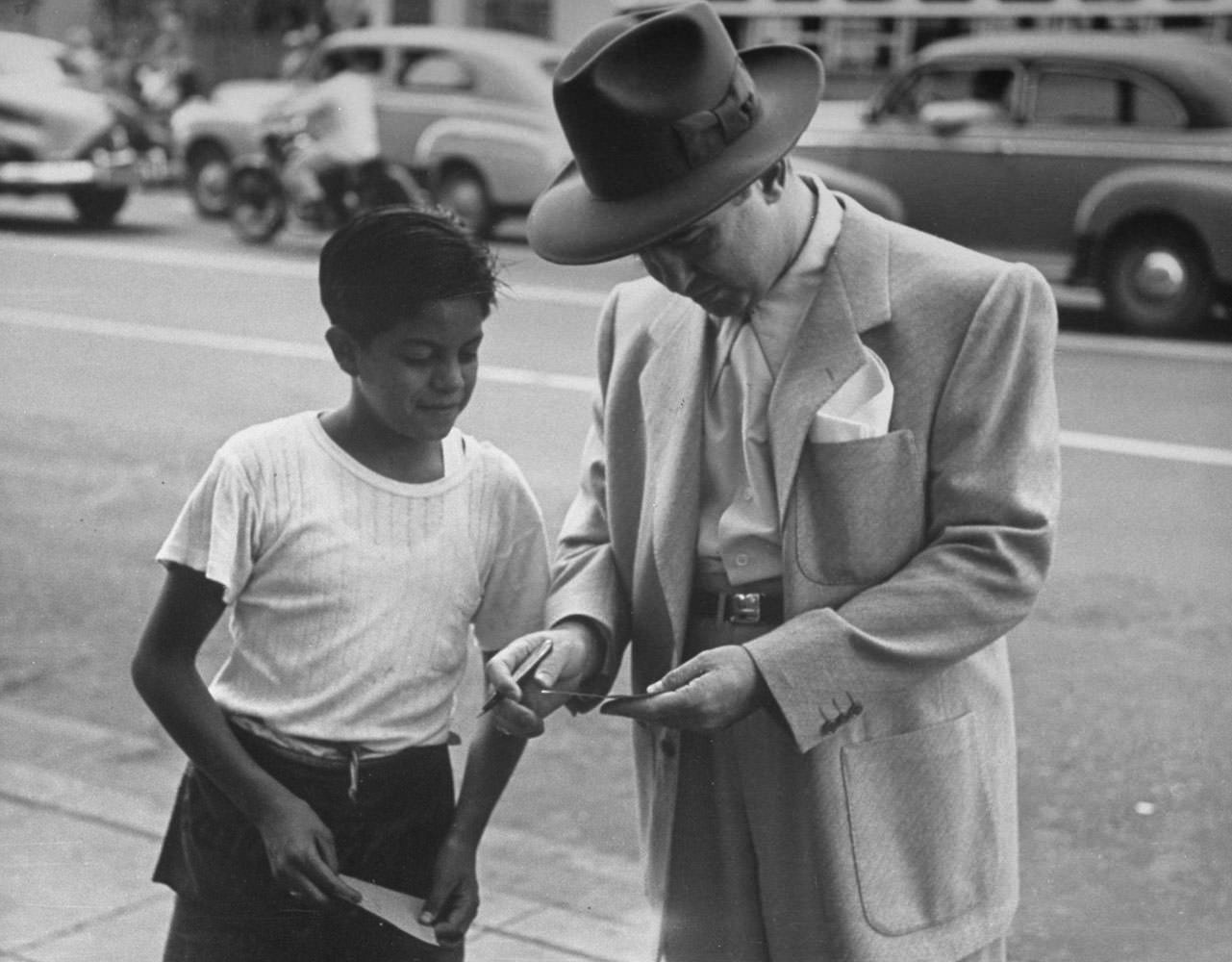 #1 Mickey Cohen signs an autograph for a young fan, Los Angeles, 1949.