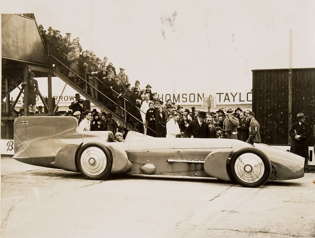 13 Sir Malcolm Campbell at the wheel of the Bluebird, with crowd, 1926 – 1936