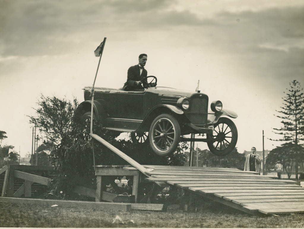 Overland car jumping a fallen bridge in a promotional stunt, 1920 – 1929