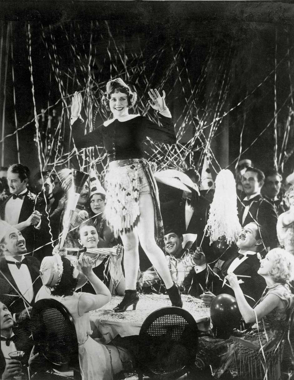 #56 A girl dancing on a table at a New Year’s party in Hollywood, 1930s.