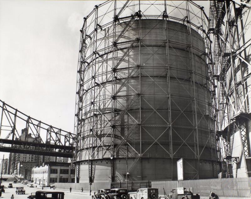 #6 Gas tank and Queensboro Bridge, East 62nd Street & York Avenue, Manhattan. Huge gas tanks dwarf Queensboro Bridge (left) and cars on street below.