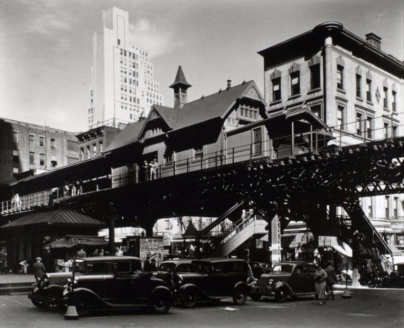 #61 Elevated railroad station in Hanover Square in Lower Manhattan, cars below, buildings of various eras beyond.