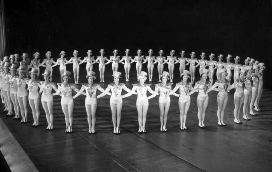 #62 In white satin and jaunty hats, the group forms a perfect circle at Radio City in December of 1944.