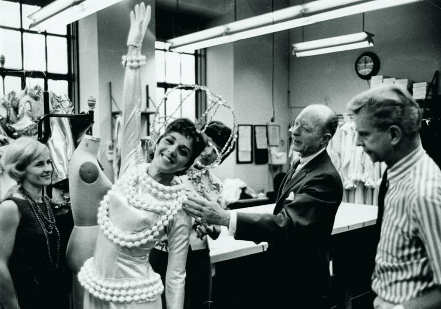 #68 A beaming, space-suited Rockette gets her astronaut gear tweaked by nasa engineers—slash, the costume shop—backstage in the 60s.