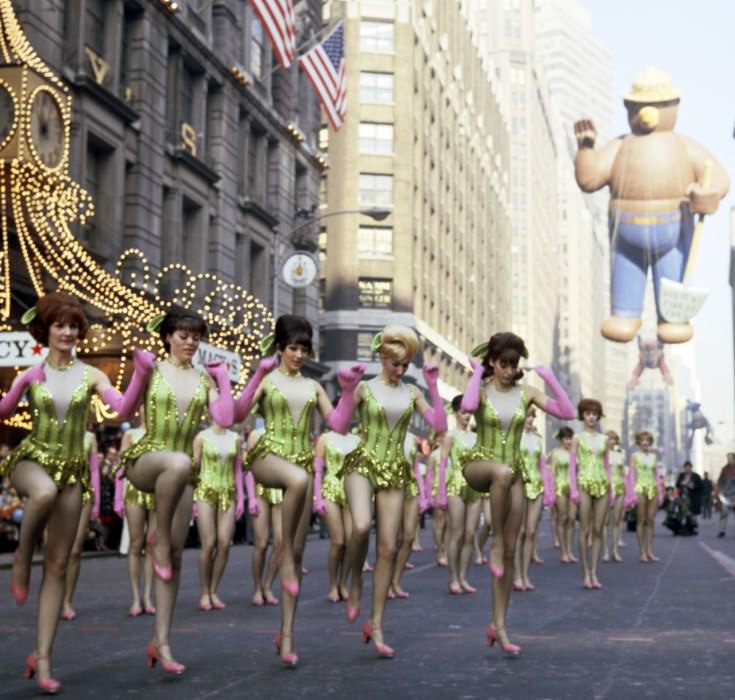 #70 Pink and green and beehives—and some tap-inspired choreography—for the parade in 1966, at which the Rockettes appear to have been the opener for Smoky the Bear (back right).