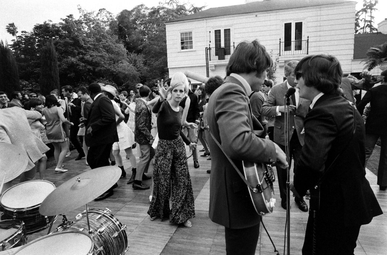#9 Twiggy (center, long dress) at a party thrown for her in Beverly Hills, 1967.