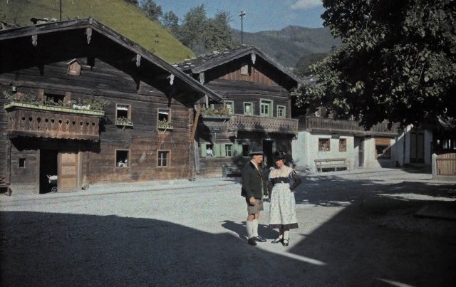 #1 A man and woman standing in the sun on a Wagrain street corner, Austria, 1929.