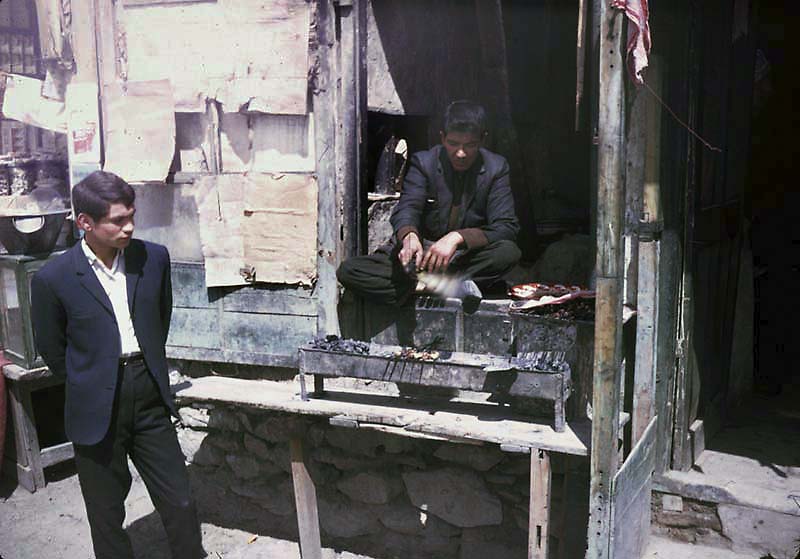 #33 Young men cooking kebabs.