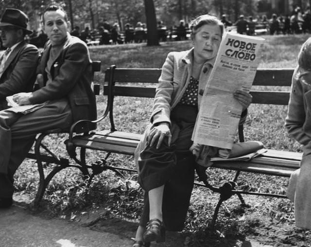 #13 A woman reading a newspaper in Washington Square Park, Greenwich Village, 1955.