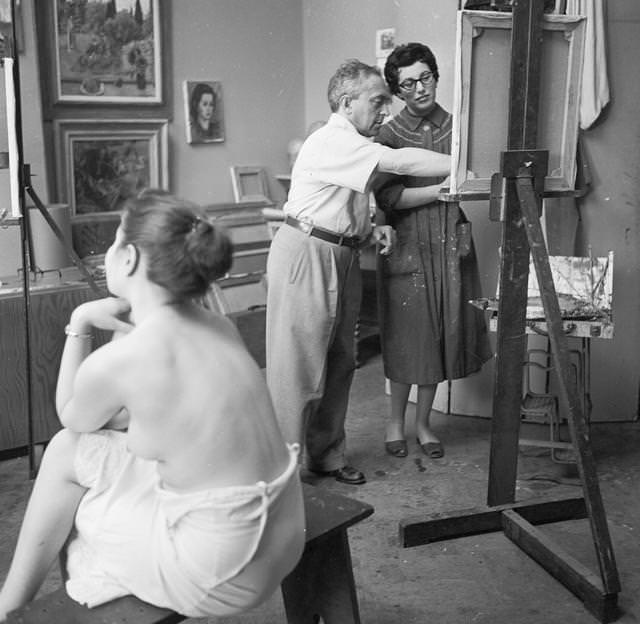 #14 American artist Moses Sawyer instructing a pupil in life model painting in his Greenwich Village studio, 1955.