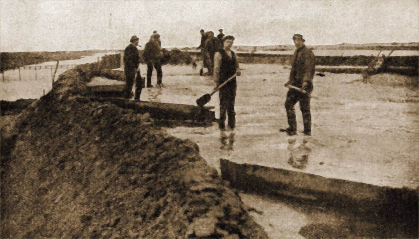 #47 Men reclaiming the Zuiderzee by laying concrete, sand and earth over brushwood, 1930s.