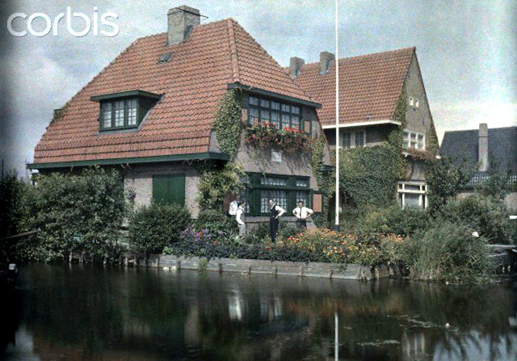 #6 Men converse in the garden of their home on the canal in Aalsmeer, 1930s.