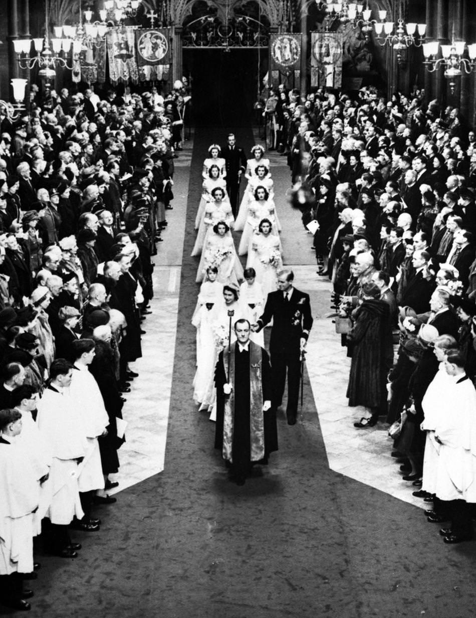 #11 Britain’s Princess Elizabeth and the Duke of Edinburgh walk down the aisle of Westminster Abbey, London, on Nov. 20, 1947, after their wedding service.