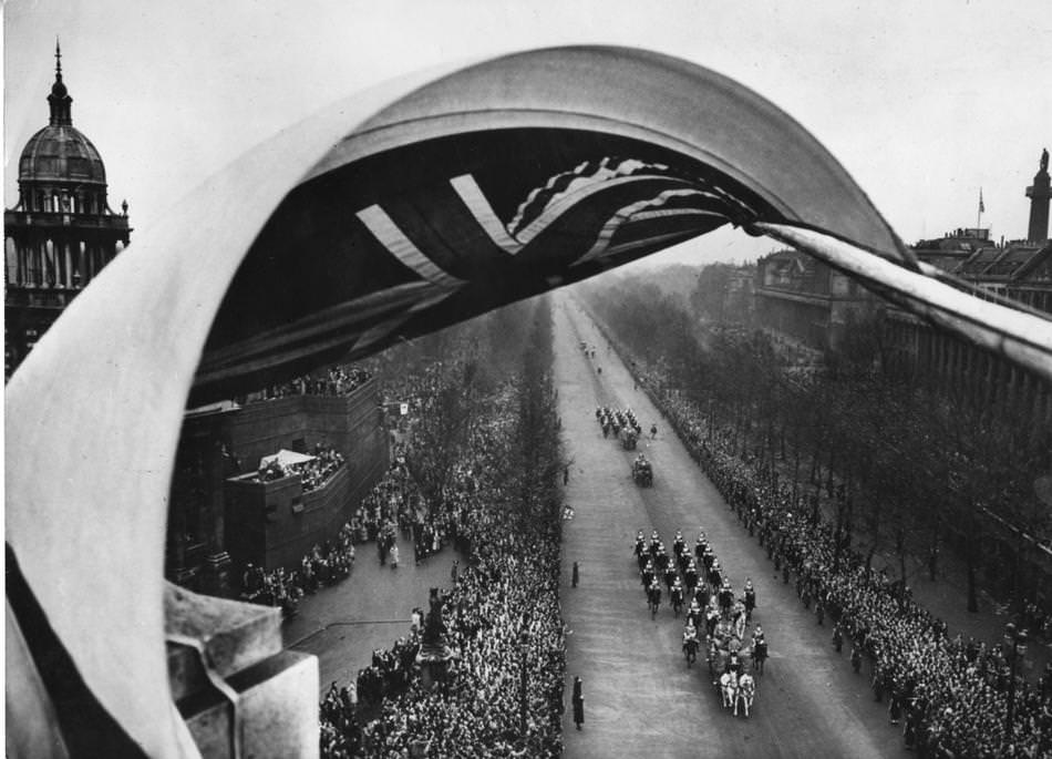 #8 A billowing flag, part of the decorations on Admiralty Arch, frames the royal bridal procession as it passes down the mall on the way to Westminster Abbey in London.