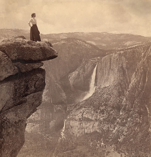 #9 A female tourist stands on the edge of Overhanging rock, nearly a mile straight down and only a step–from Glacier Point (N.W.) across valley to Yosemite Falls, Yosemite, Cal., circa 1902.